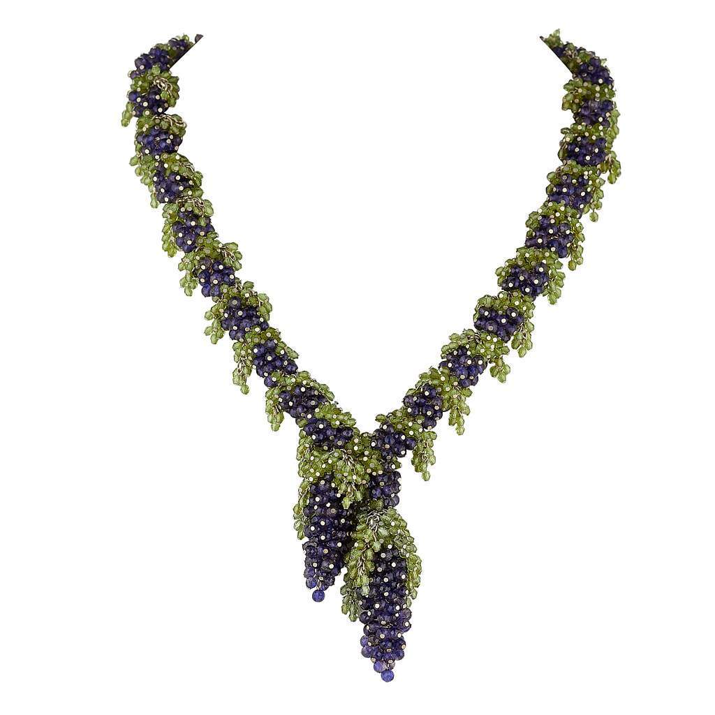 Medium length necklace with deep blue Iolite grapes and green Peridot leaves along a chain with two large deep blue grapes with green leaves hanging like a pendant in the centre.. 